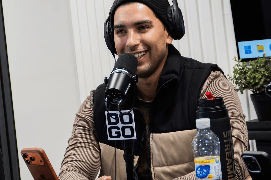 Un invitado sonriendo al micrófono Shure del estudio